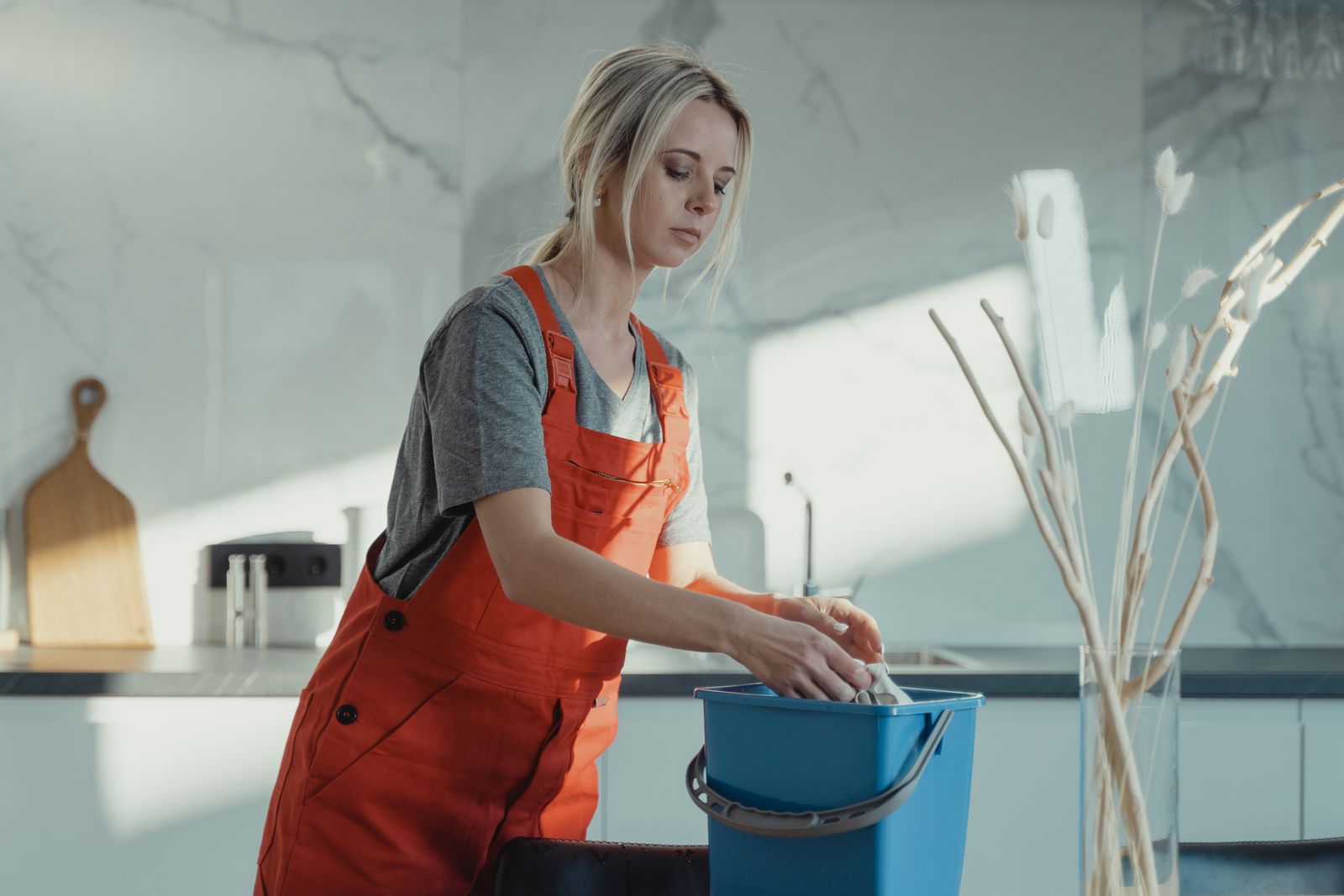 Professional cleaner working carefully in a bright modern kitchen